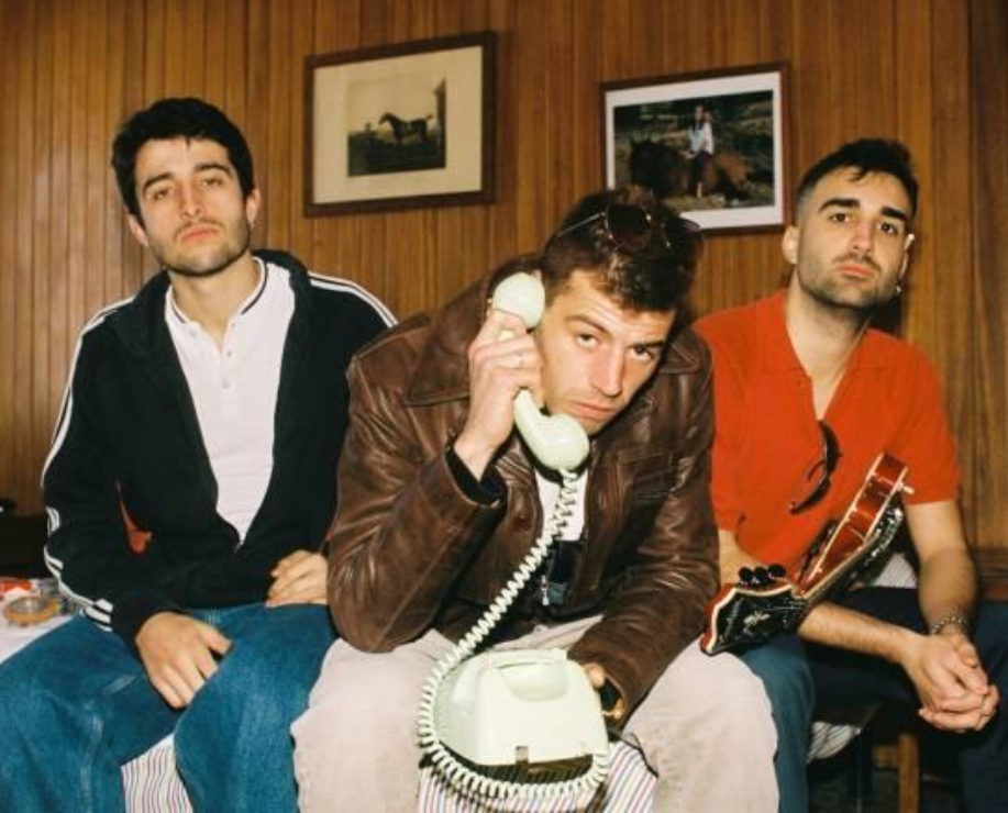 Three people with a vintage 90s rotary telephone